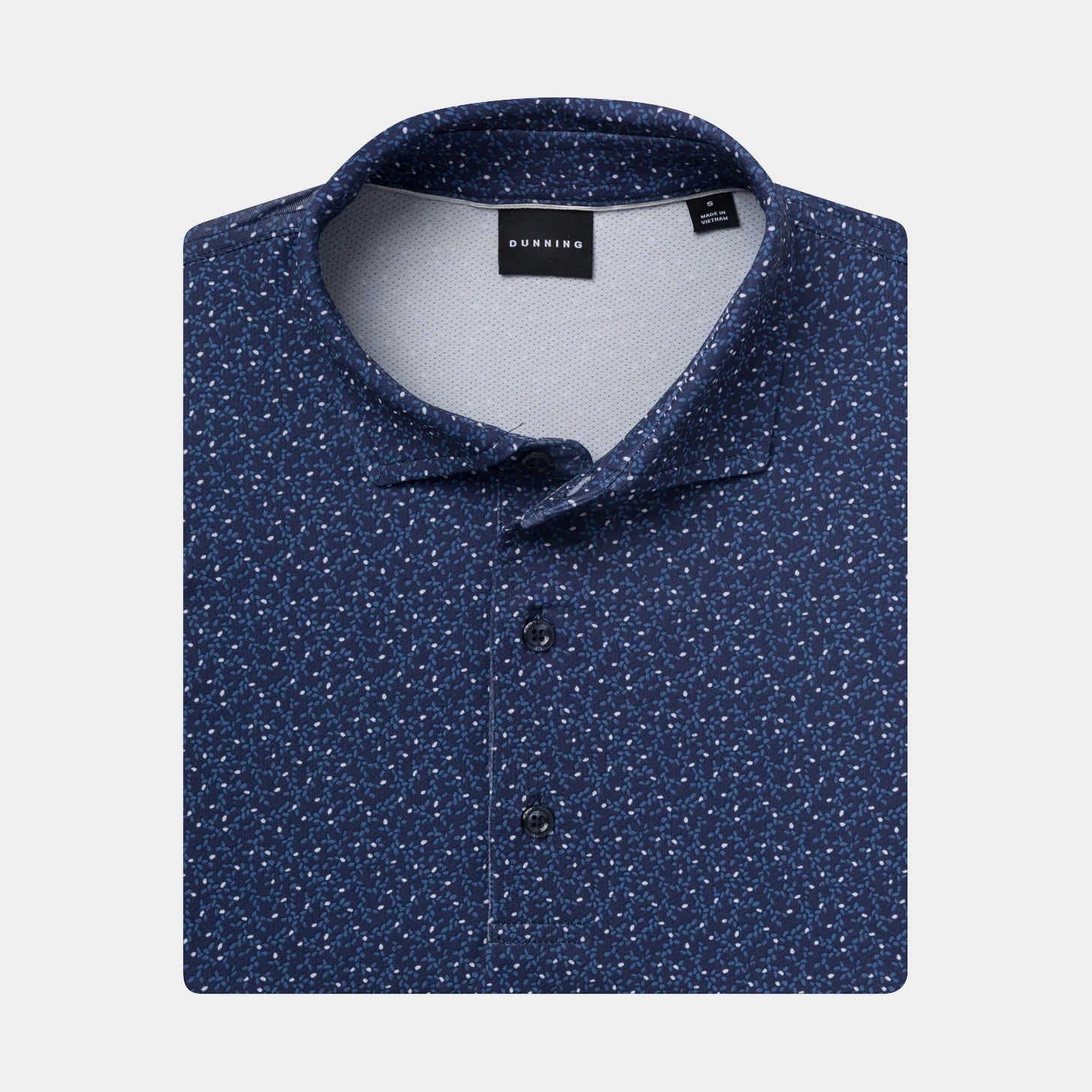 A folded dark Halo blue polo shirt with a dense white micro-dot pattern, featuring a classic collar, and button placket.