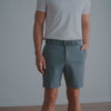 Video of a man modeling Dunning's Player Fit Woven 8" golf short, paired with a white t-shirt and woven belt, showing the fit from full-body and close-up angles including the side pocket and waistband against a plain studio background.